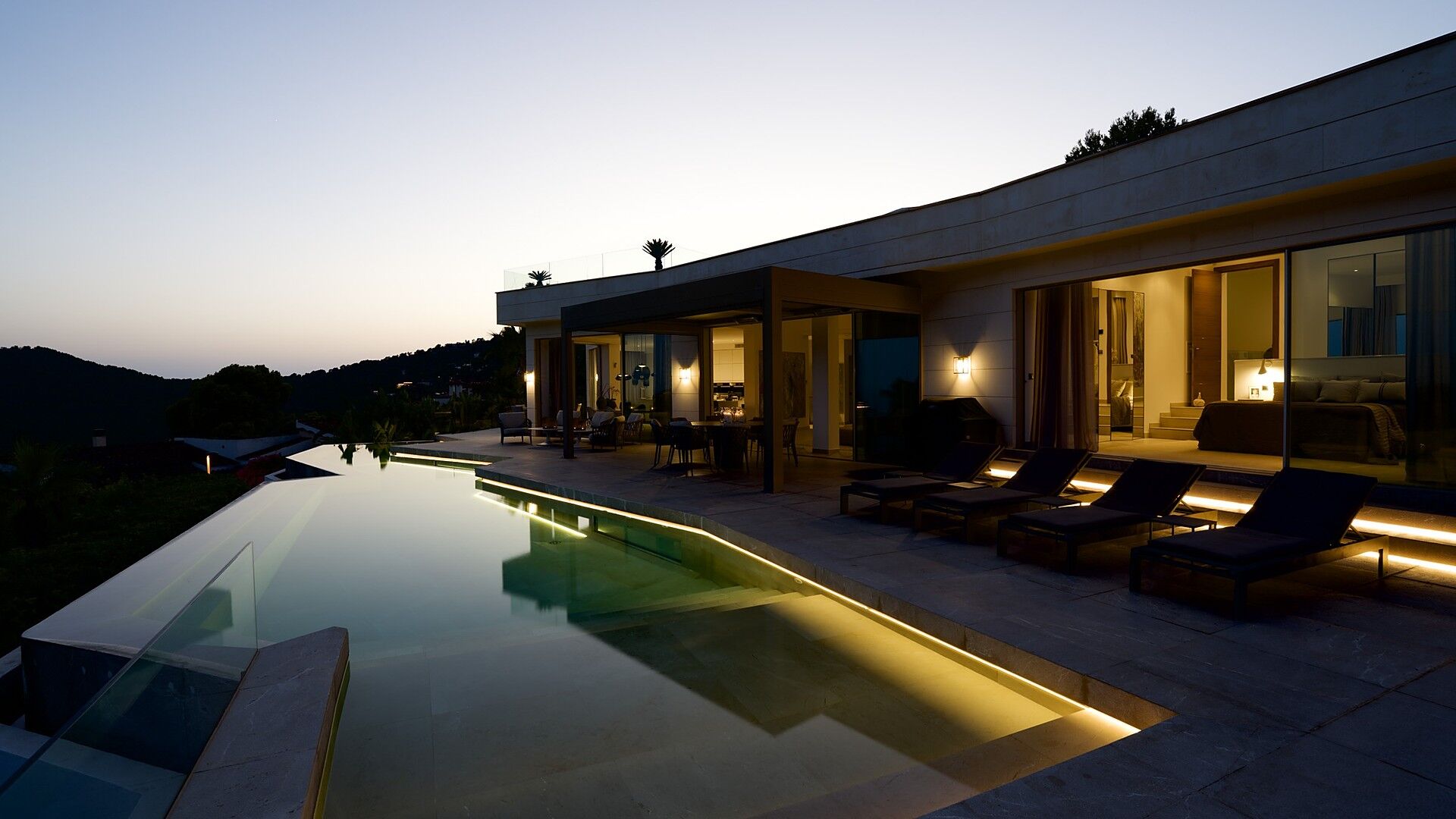 A pool terrace at dusk above the bay